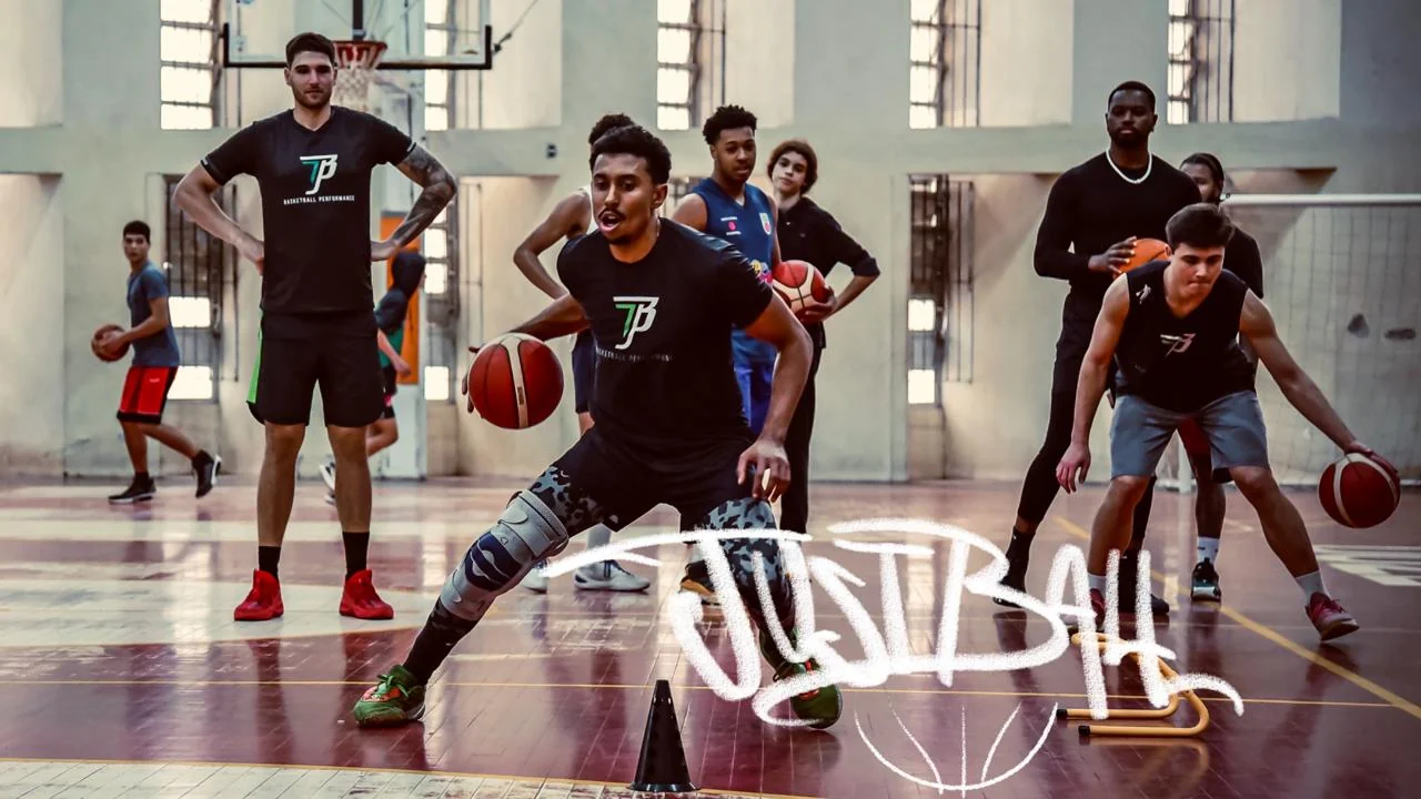 Atletas da Just Ball em treino, um deles driblando pelo meio da quadra